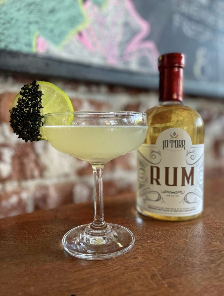 Rum bottle next to a crafted cocktail at a Reno distillery taproom